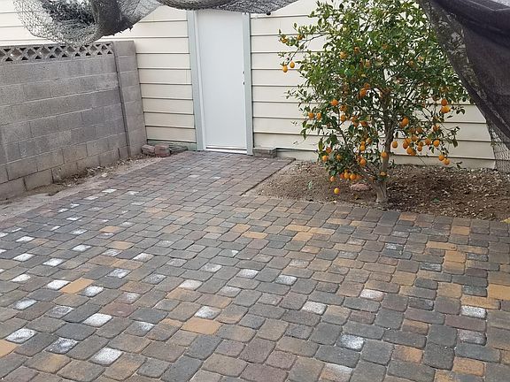 Paver patio with lemon tree with access to door leading to the 2-car garage