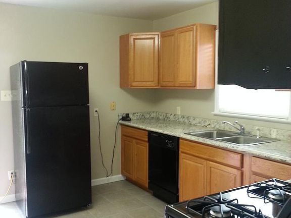 Kitchen, window looks out onto concrete patio in back yard