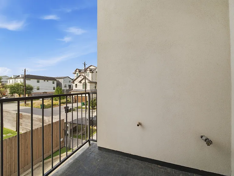 Private balcony with metal railing offering neighborhood views_perfect for fresh air, morning coffee, or relaxing outdoors.