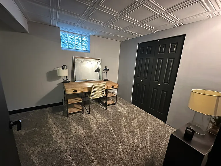 Downstairs guest room features large sliding doors to reveal full length closet.