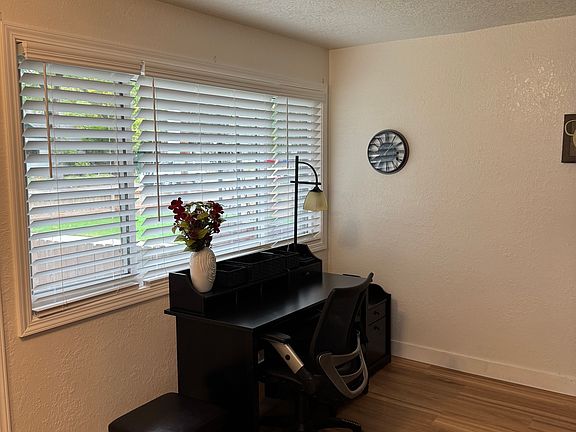 Office Desk and chair furnished near front window Living room.