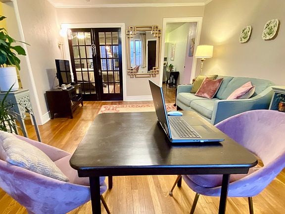 Home office/dining table looking into bedroom and kitchen