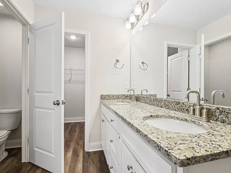 Primary bathroom with double vanity, walk-in shower and walk-in closet.