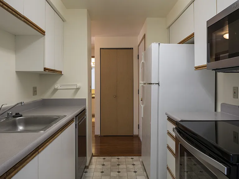 Kitchen looking thorugh to entry. Please note: refrigerator has been replaced with a stainless steel refer.