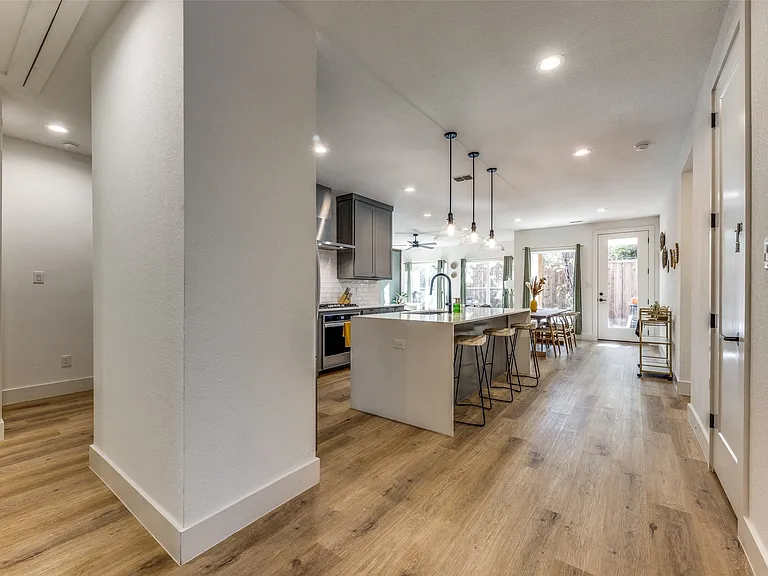 Open concept living area featuring wood-finish flooring, recessed lighting, and a contemporary kitchen