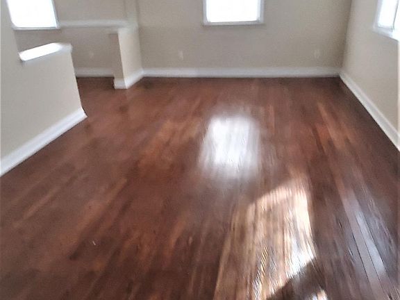 view from the upstairs into the living room and part of the dining room can be seen in this photo