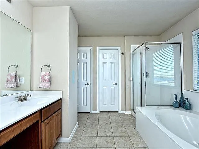 Double sinks. Private toilet entry inside right door. Towel closet inside left door. Large walk-in closet adjacent to shower (next pic)