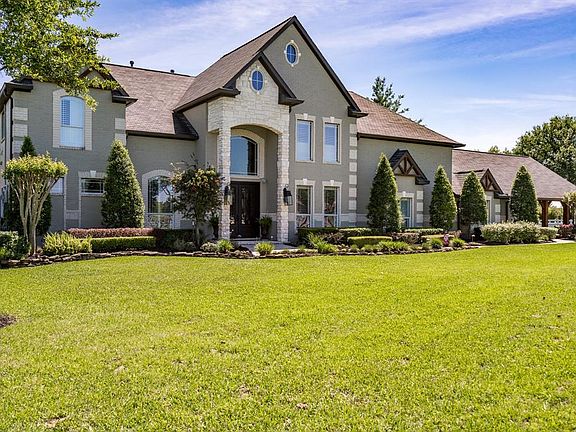 Meticulous landscaping with pretty foliate and tons of mature trees surround the brick and stone exterior of this beautiful home!