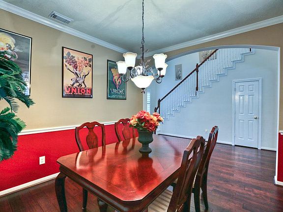 A large formal dining room is adjacent to the living room w/decorator lighting, hardwoods, and crown molding.
