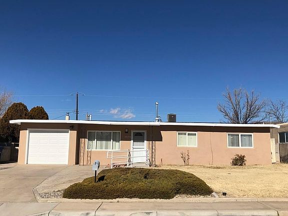 Front Yard with single car garage. All new thermal pane windows with blinds throughout. New refrigerated AC is visible on roof. (Note: these are winter photos - - in summer grass in front and back is green).
