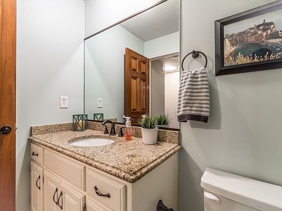 First floor powder room right off of Foyer with Solid wood door, hardwood floors and upgraded granite top.