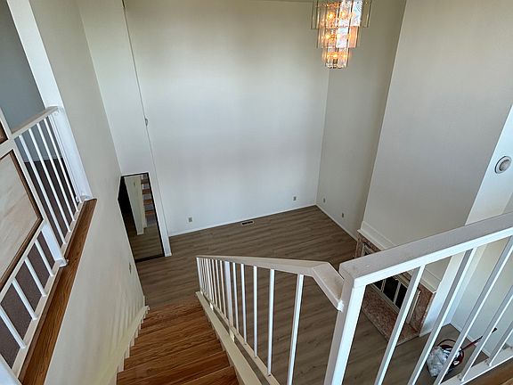 View to lower level, stairs and living room with gas fireplace