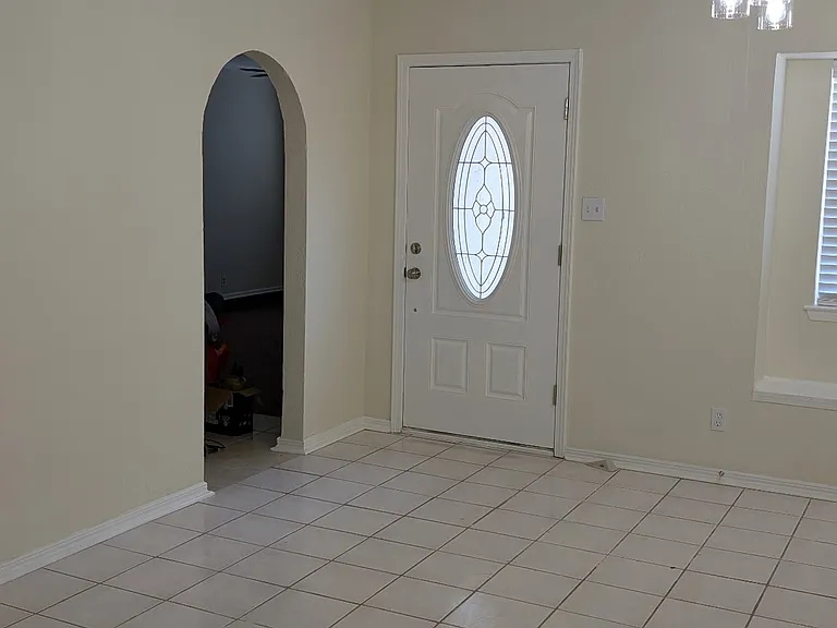 Front door and open doorway leading to den/living area.