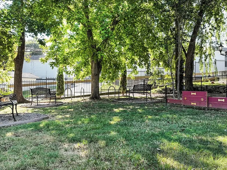 Manicured landscaping with large trees and flower beds adding natural charm throughout the property.