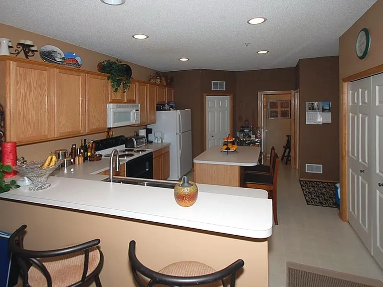 Breakfast bar with view of kitchen. Pantry is to the right. Half bath is off from the kitchen.