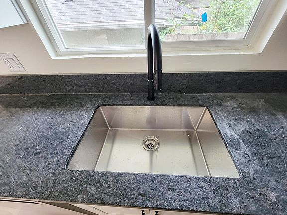 kitchen: honed granite counter tops, stainless steel under-mount sink, black/modern kitchen faucet