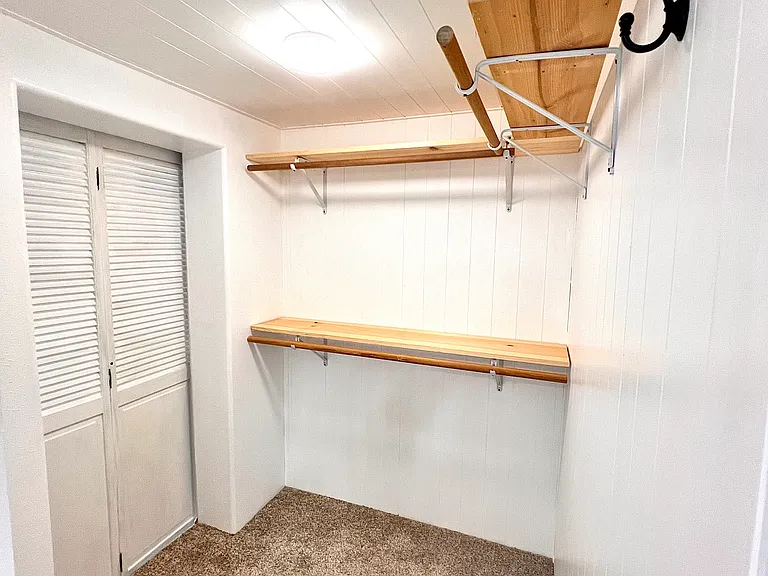 Walk in "hers" closet with door to laundry room and opening to master bath