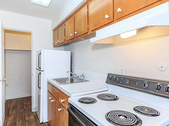 Royal Gardens - Kitchen featuring white appliances, large Formica counter tops, and tan cabinets.
