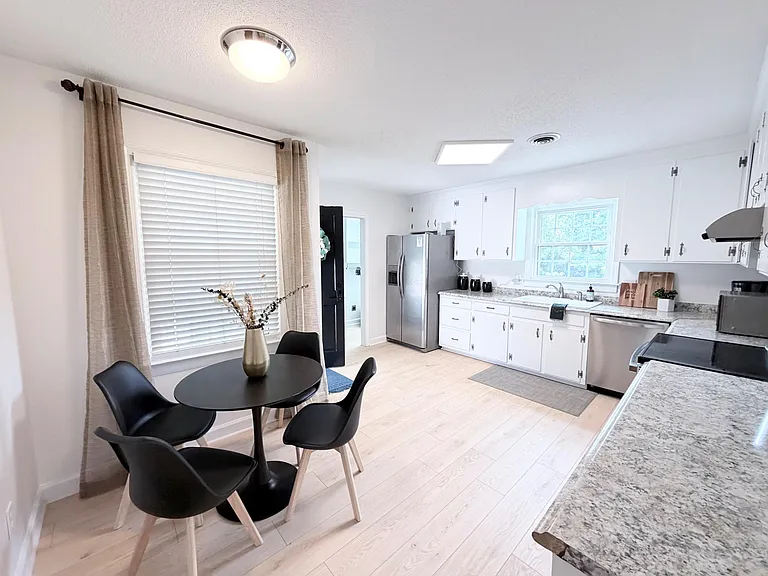 Updated eat-in kitchen with ample cabinet storage, stainless steel appliances, and a dining nook by the window.