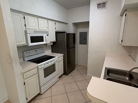 new fridge, dishwasher, microwave, sink and stacked washer/dryer