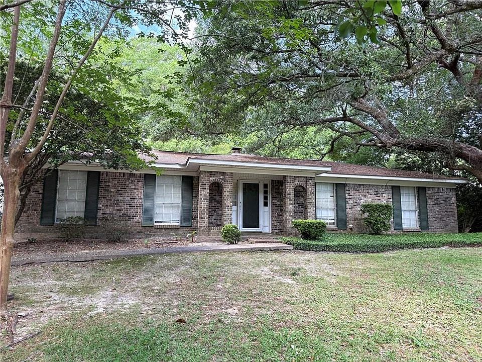 Single story home featuring a front yard and brick siding