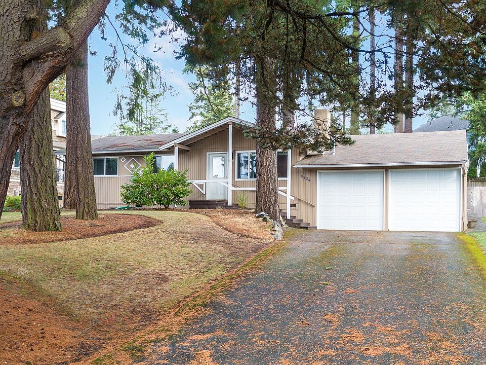 Front of house w/ long driveway and two car garage