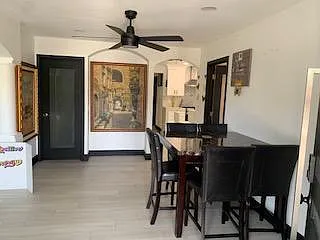 Open dining area with a bar-height table, ample seating, and direct access to adjacent rooms for easy everyday meals.