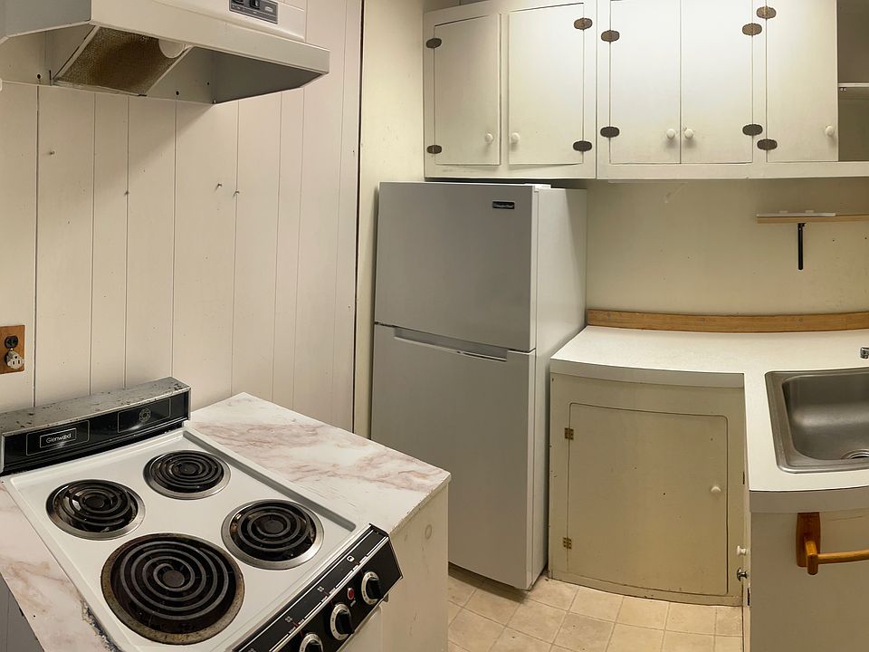 Kitchenette with Electric range, fridge/freezer, cabinets, and stainless steel sink. Currently modernizing range with induction burners/ceramic top plus oven.