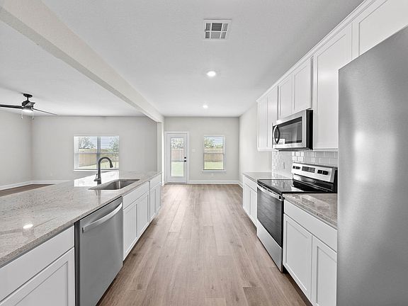 The kitchen of the Cypress has gorgeous white good cabinetry.