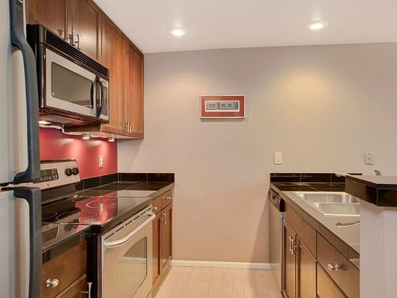 Kitchen opens to living area. Granite counters, breakfast bar, SS appliances & beautiful cabinetry.