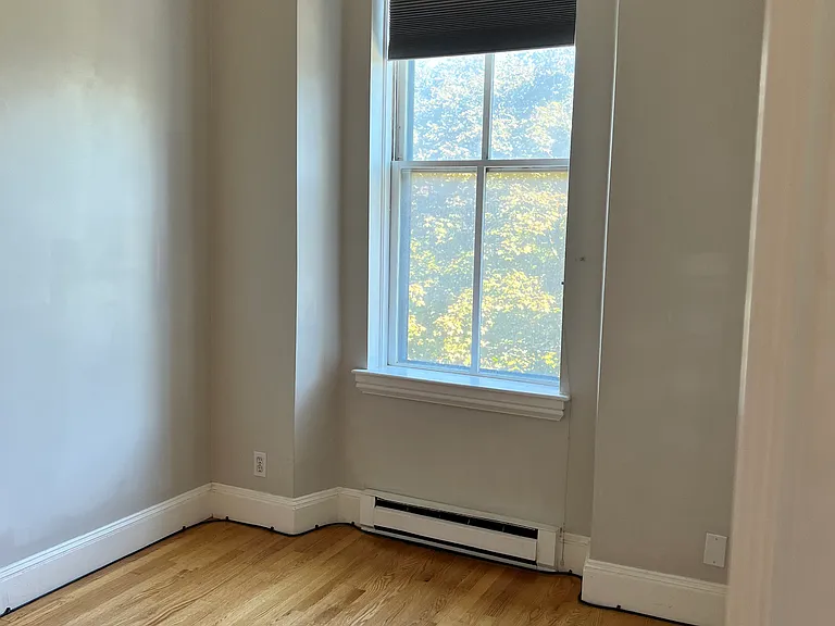 Bright bedroom with a large window overlooking Blackstone Square. Comfortably fits a queen-size bed.