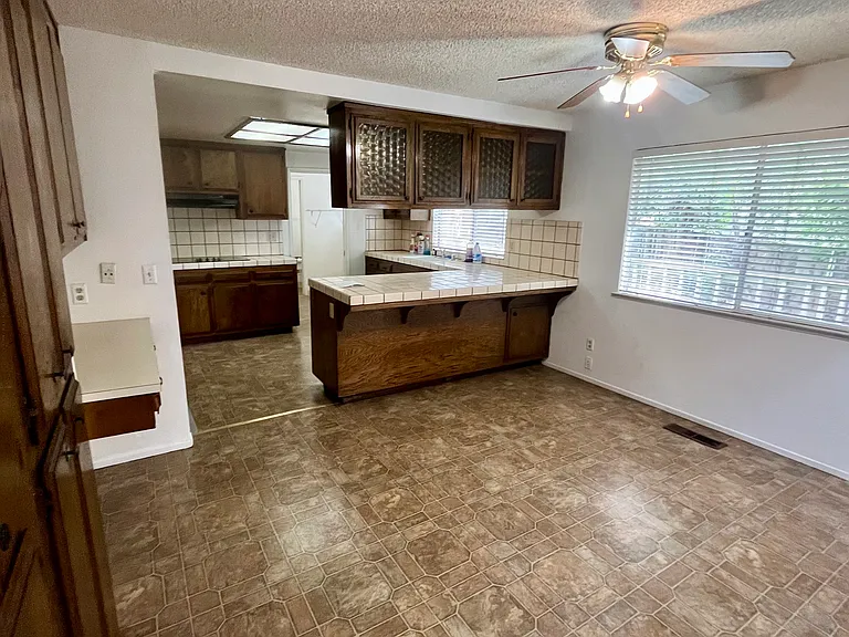 Peninsula breakfast bar and dinette space. In the background, there is a laundry room and a half bathroom.