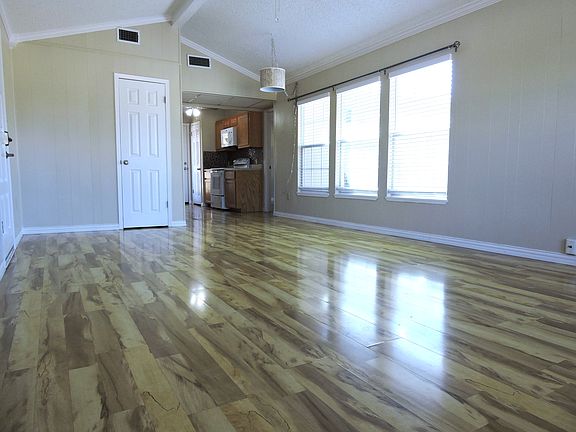 Huge windows with blinds and curtain rods in every room.