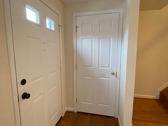 Coat Closet and front entry into living room with stairs leading to 2nd floor