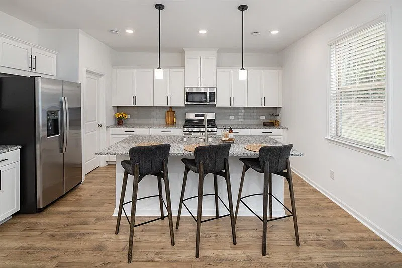 View of the kitchen and entry hallway. Offering bar seating, plenty of cabinet space and granite countertops.
