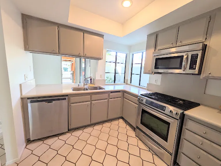 Newly painted kitchen cabinets. Stainless steel appliances.
