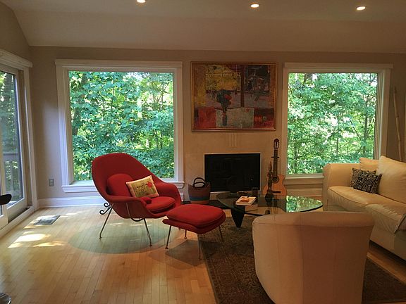 Living Room w/ picture windows providing loads of natural light and serene view of fireplace and view into woods.