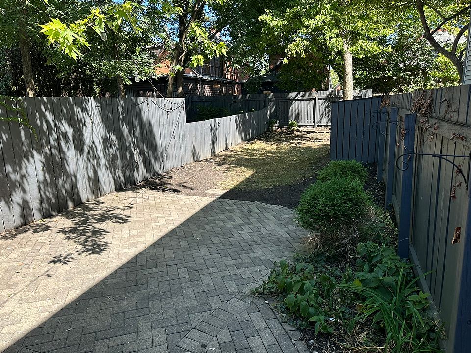 Backyard with brick patio, fenced in yard, shed