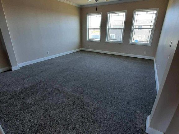 Captivating, spacious open living area adjacent to the kitchen features fresh neutral paint color, new 52" ceiling fan and blinds.