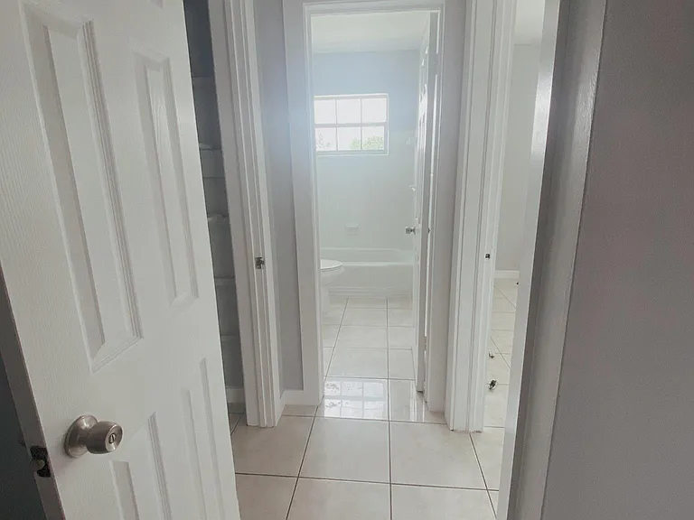 Hallway to bathroom (center), closet (left) , and bedroom (right)