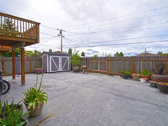 Enjoy the afternoon sun in the back yard. Double doors lead out to the alley with parking for 3-4 cars. Your boat too!. Storage and garden shed stay with the home. Loads of room for the barbecue and picnic tables. Lots of summer fun