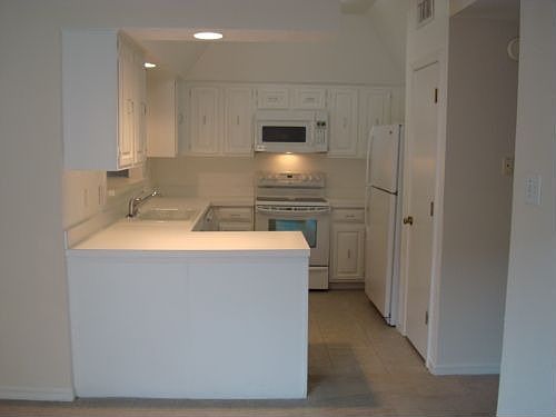 Kitchen with bar area, Open to living room and dining room, New Applicances and tile foor. Refrigera