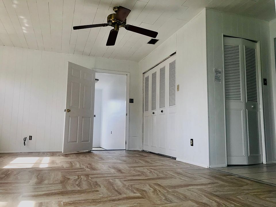 Large bright family room leading to hallway to outside and large utility room