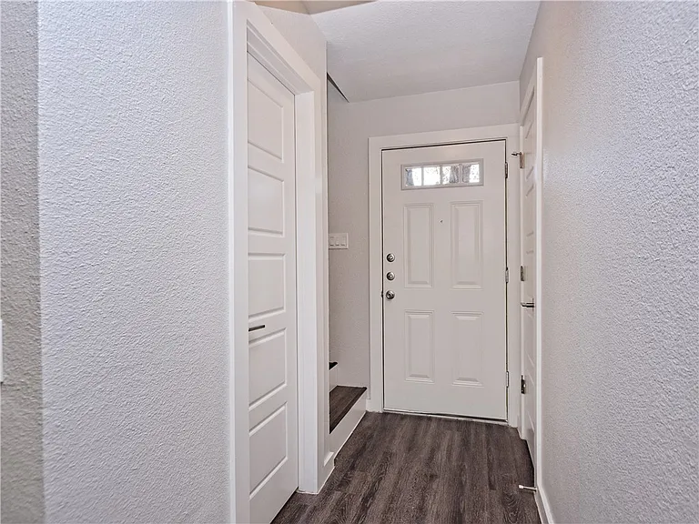 Front hallway. Coat closet and half bath doors. Stairs to 2nd floor and bedrooms on left.