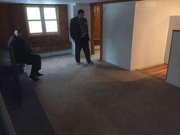 Living room with fireplace (looking into kitchen area)