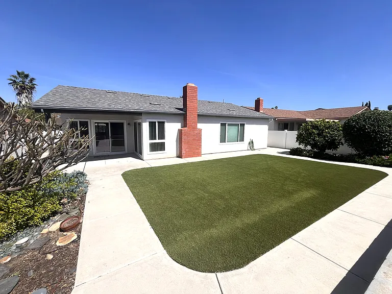 Backyard with adjacent gardens.