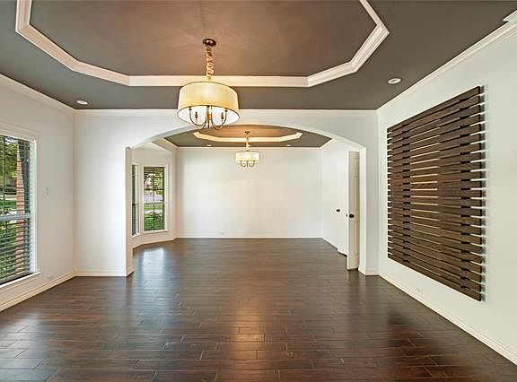 Formal living room, with formal dining in the background. Hardwood floor, with lots of outdoor light.