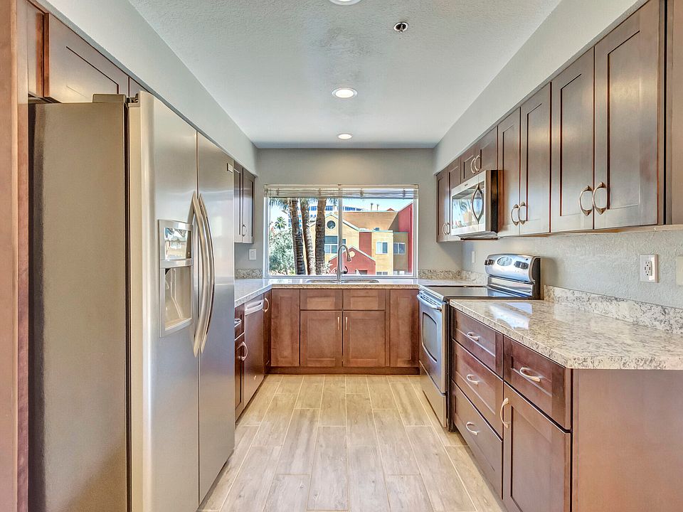 Kitchen with view of pool, granite countertops, stainless steel appliances, garbage disposal and dishwasher