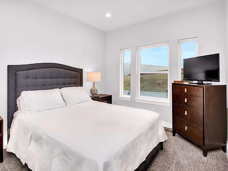Bedroom with queen bed, closet (not pictured), and smart tv