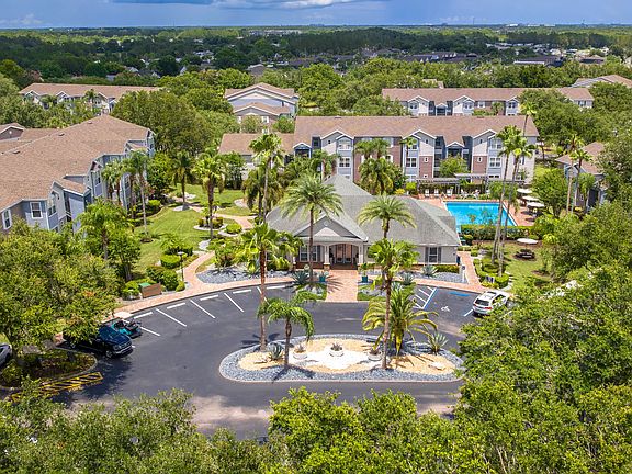 Discover the lush, resort-style layout of Ashton Chase Apartmentsfeaturing vibrant landscaping, a sparkling pool, and spacious apartment homes.